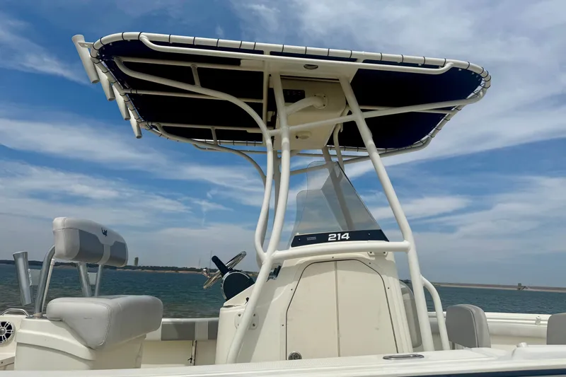 Slide: The Image of 2024 Mako 214 Center Console boat with T-top on open water. - 2