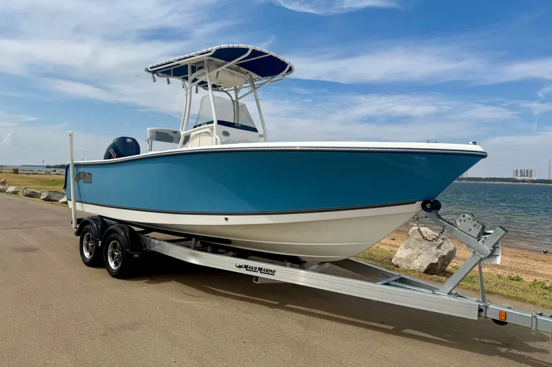 Slide: The Image of 2024 Mako 214 Center Console boat on trailer by the waterfront. - 4