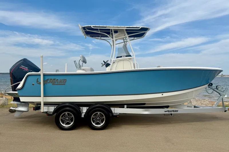 Slide: The Image of 2024 Mako 214 Center Console boat on trailer by the water. - 1