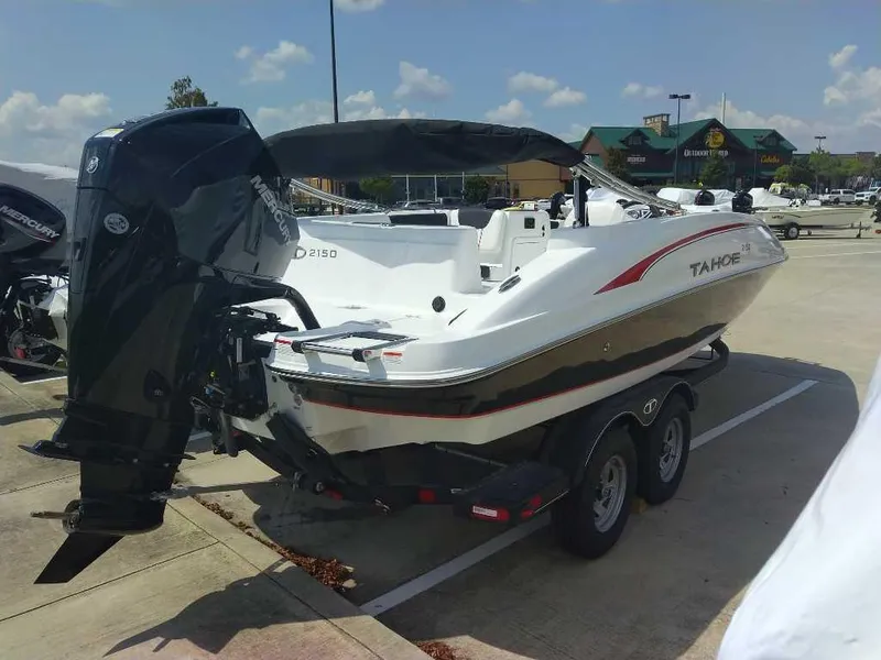 Slide: The Image of 2024 Tahoe 2150 boat on trailer in parking lot, sunny day. - 2