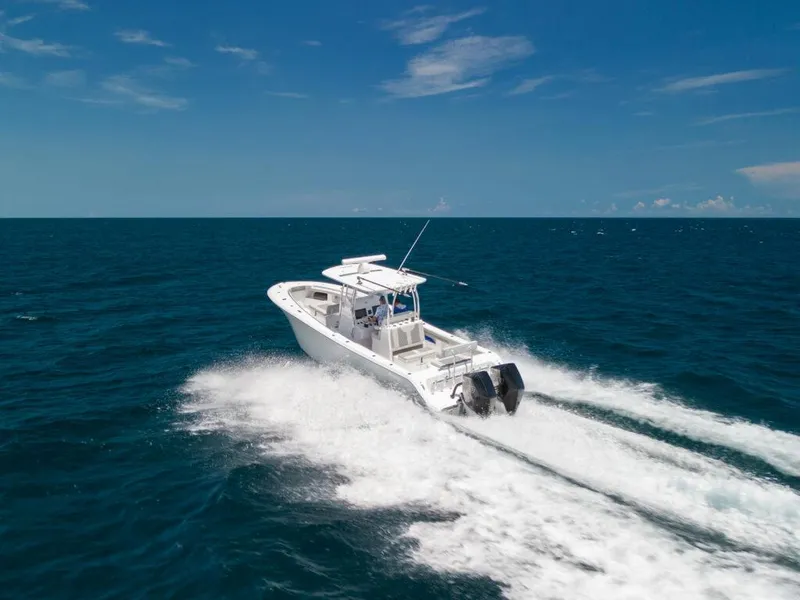 Slide: The Image of 2025 Front Runner 33 CC Custom boat cruising on open ocean under clear blue sky. - 11