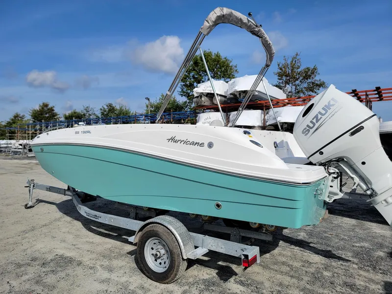 Slide: The Image of 2024 Hurricane SunDeck Sport 192 RL OB boat on trailer with Suzuki outboard motor. - 2