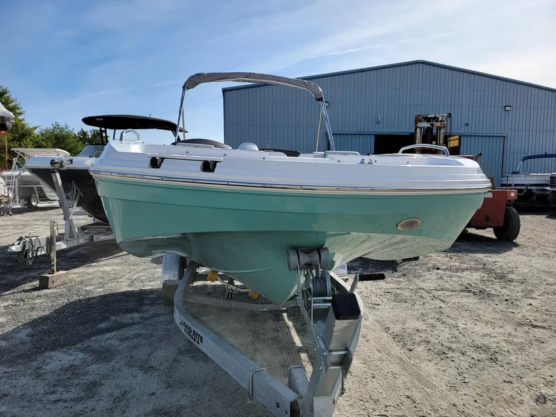 Slide: The Image of 2024 Hurricane SunDeck Sport 192 RL OB boat on a trailer in a marina. - 7