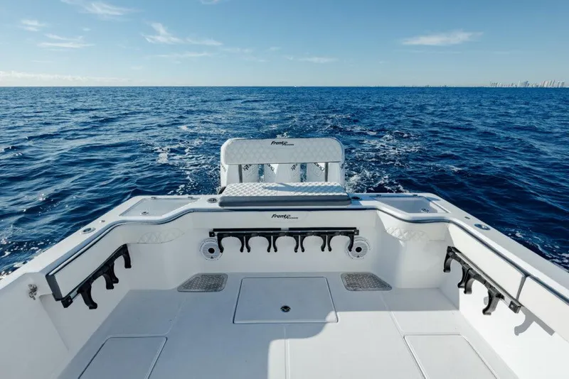 Slide: The Image of 2025 Front Runner 36 CC Custom boat on open ocean, showcasing spacious deck and rod holders. - 7