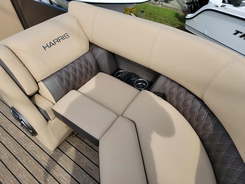 Slide: The Image of 2024 Harris Sunliner 210 boat interior with beige and brown cushioned seating. - 11