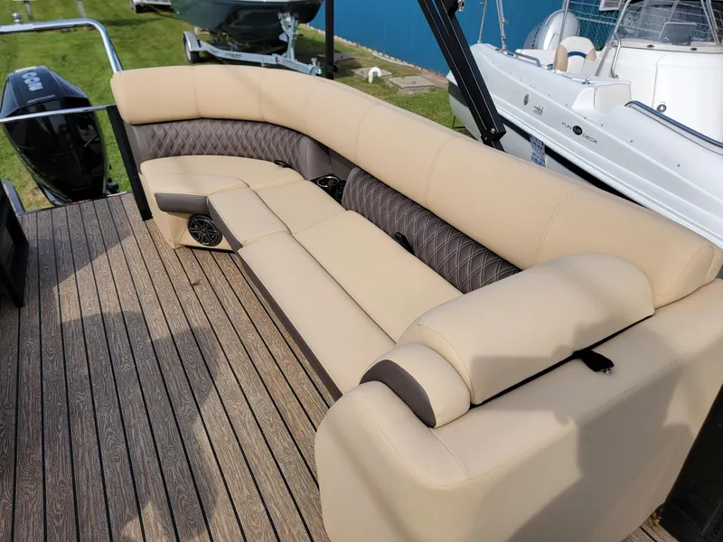 Slide: The Image of 2024 Harris Sunliner 210 boat with beige and brown cushioned seating. - 13