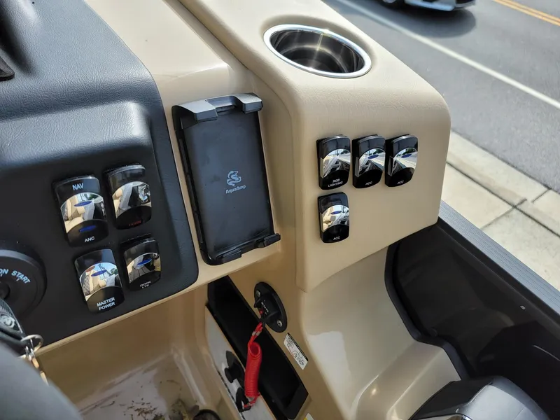 Slide: The Image of Control panel of 2024 Harris Sunliner 210 boat with switches and cup holder. - 18