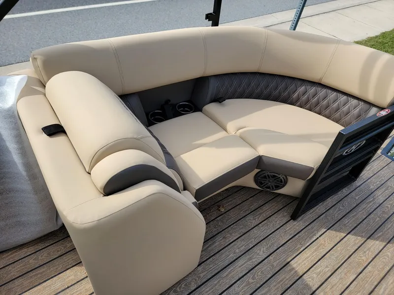 Slide: The Image of 2024 Harris Sunliner 210 boat interior with beige and black seating on wooden deck. - 22