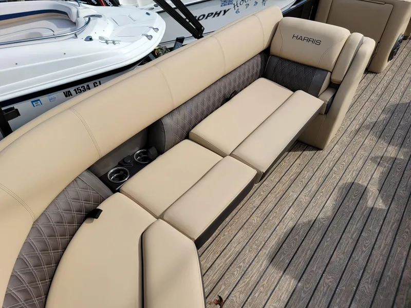 Slide: The Image of 2024 Harris Sunliner 210 boat with beige seating and cup holders. - 27