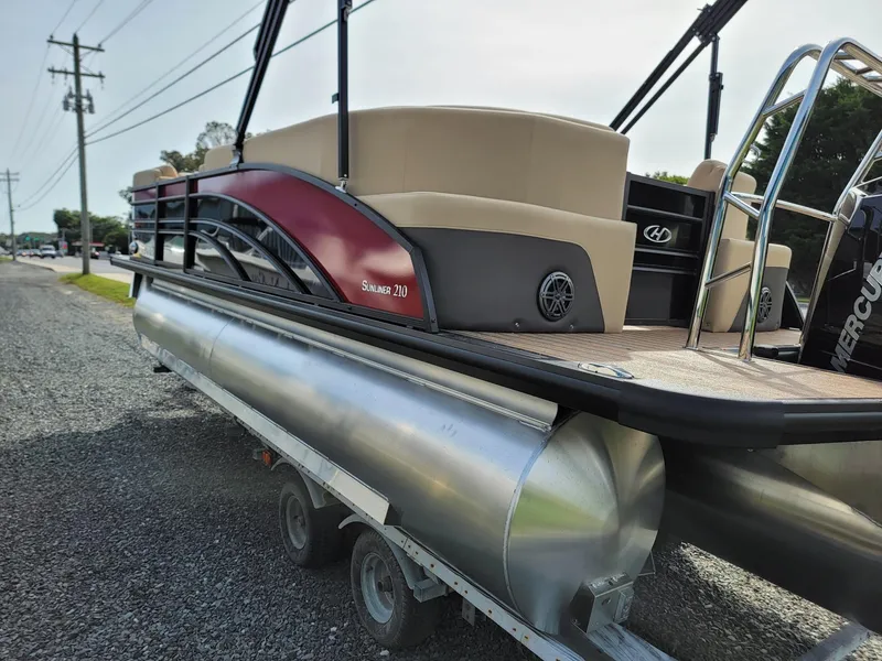 Slide: The Image of 2024 Harris Sunliner 210 pontoon boat on a trailer, side view. - 5