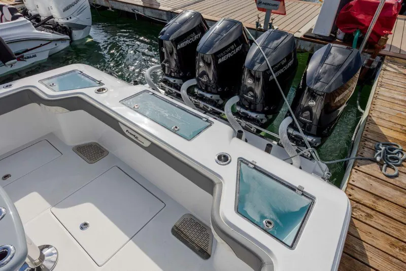 Slide: The Image of 2024 Front Runner 39 CC Custom boat with four Mercury outboard engines docked. - 11