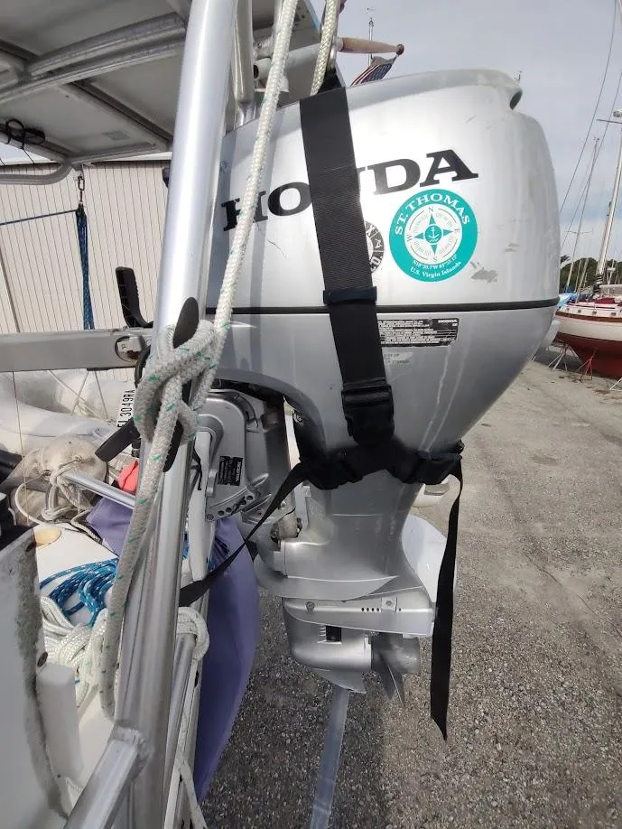 Slide: The Image of Outboard motor on a 1981 Bruce Roberts 450 sailboat, docked with visible ropes and equipment. - 32