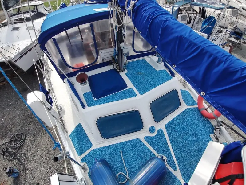 Slide: The Image of 1981 Bruce Roberts 450 sailboat with blue deck and canopy, docked in a marina. - 35