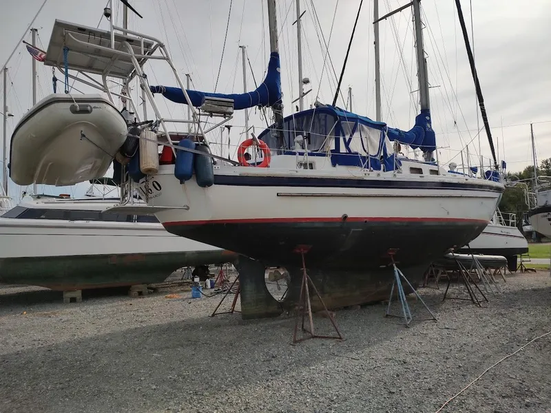 Slide: The Image of 1981 Bruce Roberts 450 sailboat on dry dock with blue covers and dinghy. - 4
