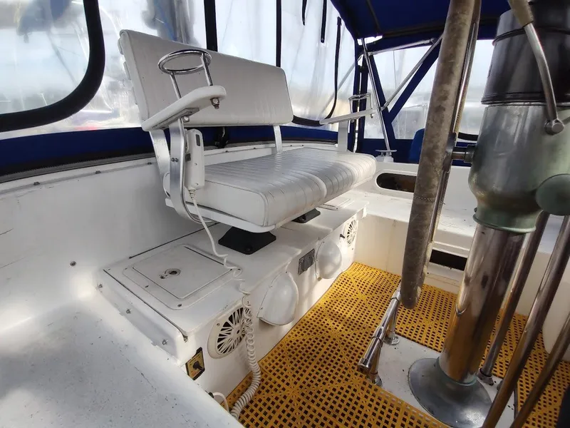Slide: The Image of Captain's chair on 1981 Bruce Roberts 450 boat, featuring white upholstery and nautical equipment. - 43