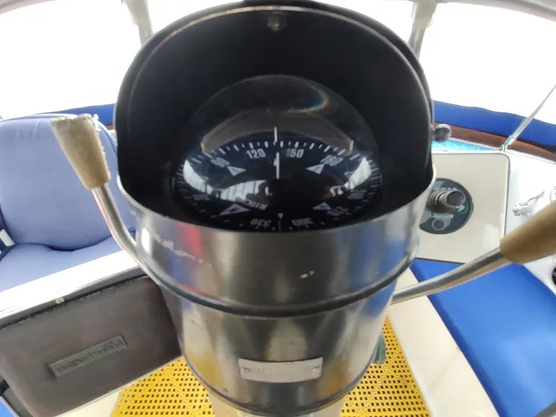 Slide: The Image of Compass on Bruce Roberts 450 sailboat, 1981 model, with blue seating in the background. - 49