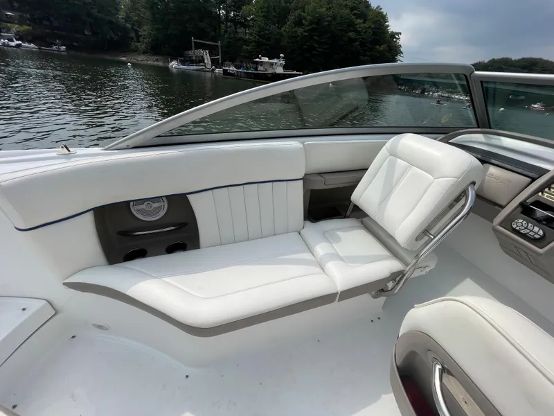 Slide: The Image of 2006 Cobalt 24SX boat interior with white leather seats on a lake. - 12