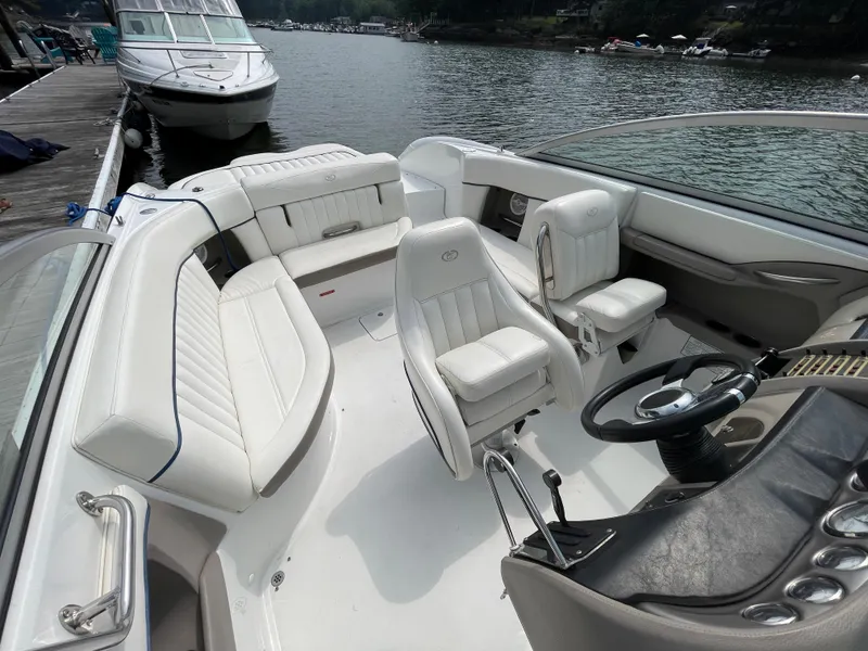 Slide: The Image of 2006 Cobalt 24SX boat interior with white seating, docked by the water. - 14