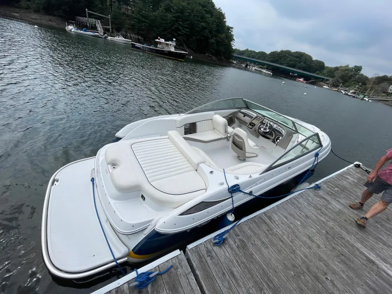 Slide: The Image of 2006 Cobalt 24SX boat docked on a serene lake. - 2