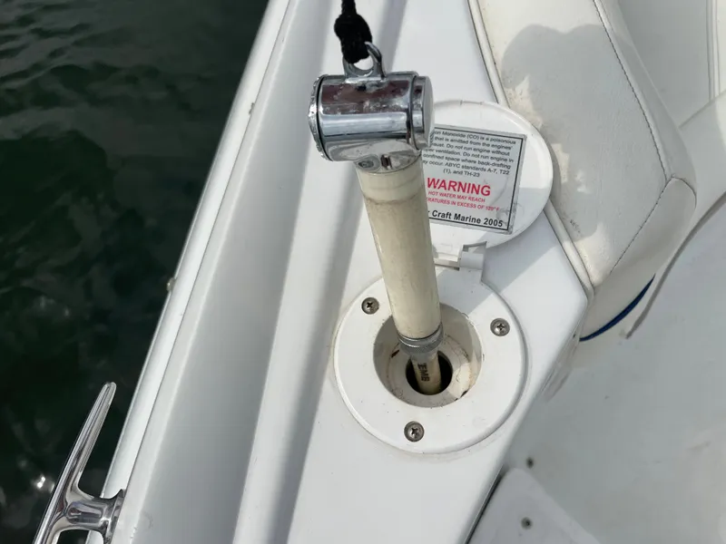 Slide: The Image of 2006 Cobalt 24SX boat detail showing a mounted rod holder and warning label. - 38