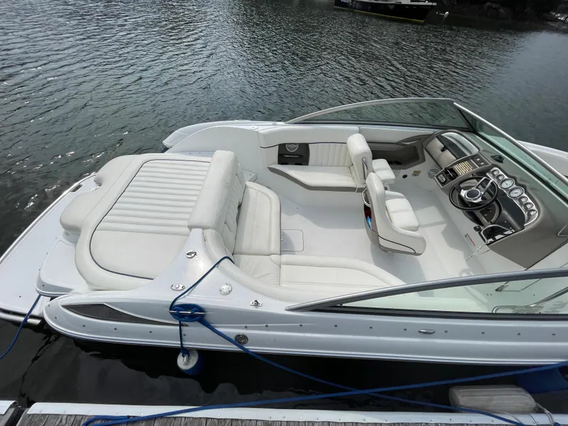 Slide: The Image of 2006 Cobalt 24SX boat with white leather interior docked on water. - 4