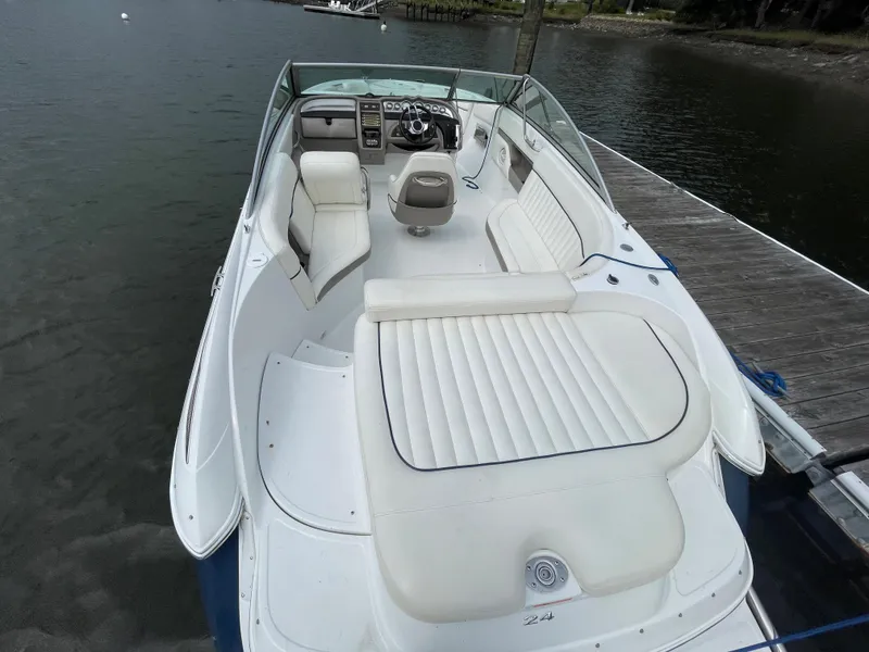Slide: The Image of 2006 Cobalt 24SX boat with white seating, docked by the water. - 6