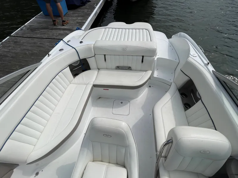 Slide: The Image of 2006 Cobalt 24SX boat with white leather seating, docked by the water. - 8