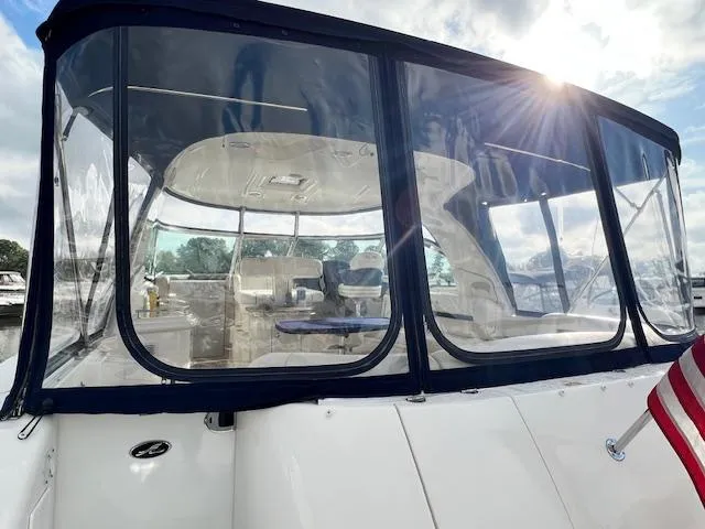 Slide: The Image of 2005 Sea Ray 500 Sundancer yacht with enclosed cockpit, American flag, and sunlit sky. - 10