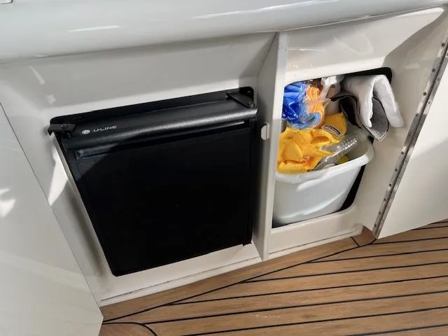 Slide: The Image of Mini fridge and storage compartment on 2005 Sea Ray 500 Sundancer yacht. - 16