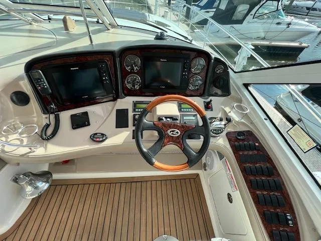 Slide: The Image of Helm of 2005 Sea Ray 500 Sundancer with wood accents and modern navigation equipment. - 38