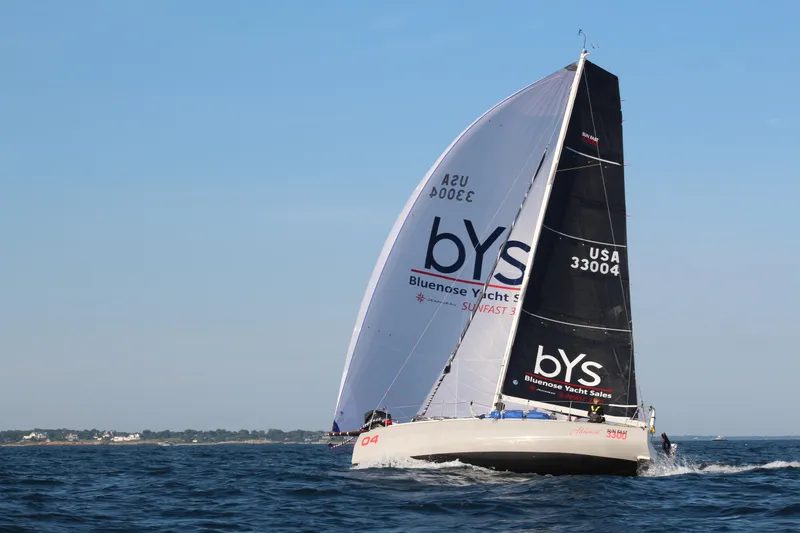 Slide: The Image of 2023 Jeanneau Sun Fast 3300 sailing on open water with branded sails. - 5