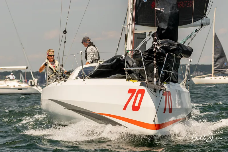 Slide: The Image of 2023 Jeanneau Sun Fast 3300 sailboat racing on open water, number 70 visible. - 8