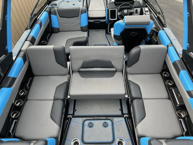 Slide: The Image of 2021 Malibu M220 boat interior with blue and gray seating. - 11