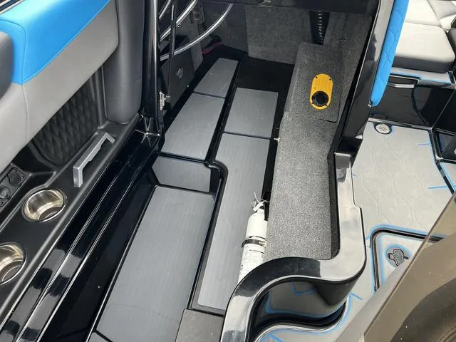 Slide: The Image of 2021 Malibu M220 boat interior with blue and gray accents, cup holders, and storage compartments. - 12
