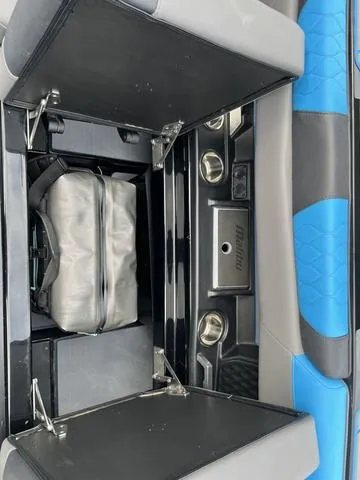 Slide: The Image of 2021 Malibu M220 boat storage compartment with blue and gray seating. - 13