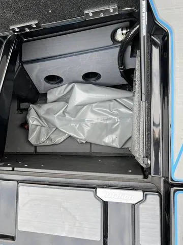 Slide: The Image of 2021 Malibu M220 storage compartment with gray cover. - 14
