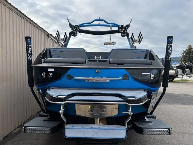 Slide: The Image of 2021 Malibu M220 boat rear view with blue and black detailing. - 3