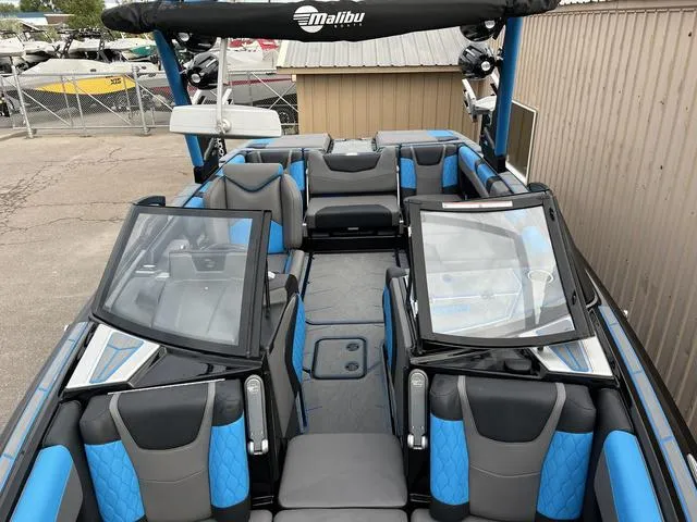 Slide: The Image of 2021 Malibu M220 boat interior with blue and gray seating. - 4