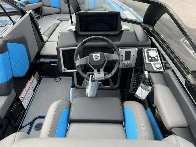 Slide: The Image of 2021 Malibu M220 boat interior, featuring modern dashboard and blue-accented seating. - 9