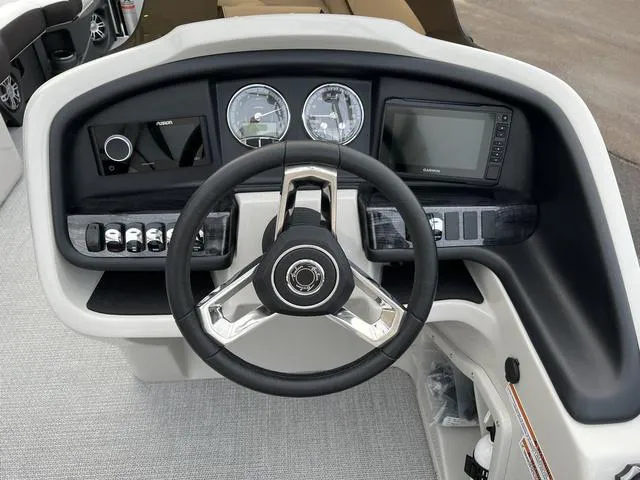 Slide: The Image of 2023 Avalon 25 Catalina Rear J Lounger boat dashboard with steering wheel and control panel. - 6