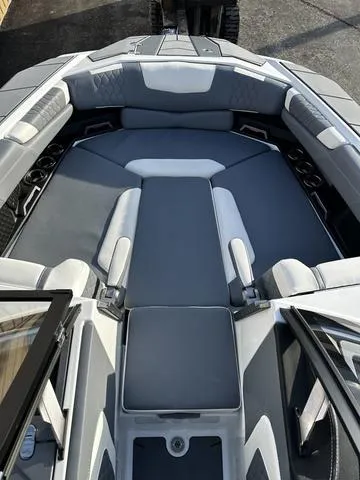 Slide: The Image of 2023 Malibu M240 boat interior with gray and white seating and advanced audio system. - 7