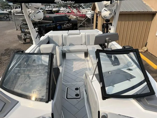 Slide: The Image of 2024 Malibu 23 LSV boat interior with white seating and open windshield. - 14