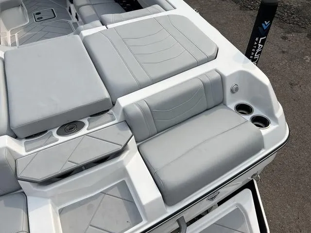 Slide: The Image of 2024 Malibu 23 LSV boat interior with gray seating and cup holders. - 7