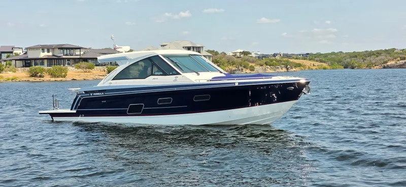 Slide: The Image of 2021 Formula 380 Super Sport Crossover boat on a scenic lake. - 0