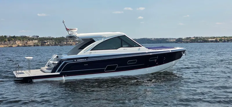 Slide: The Image of 2021 Formula 380 Super Sport Crossover yacht on calm water, scenic background. - 2