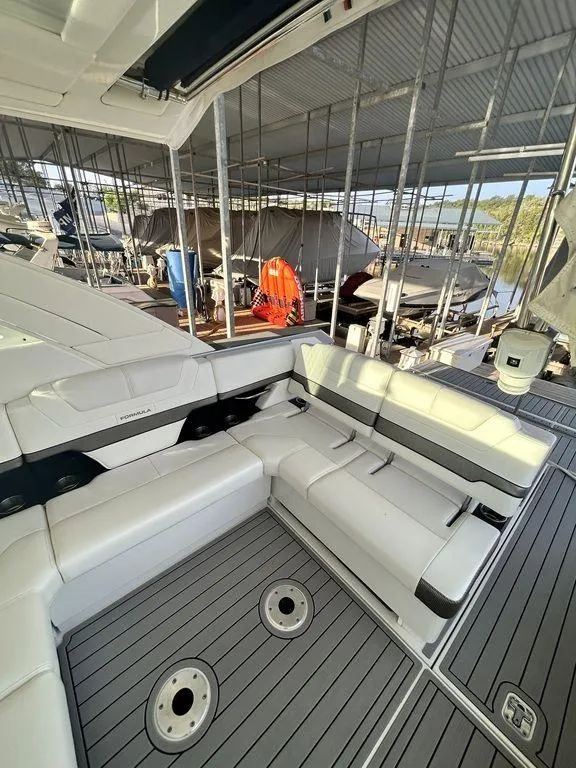Slide: The Image of 2021 Formula 380 Super Sport Crossover yacht with sleek seating in a marina. - 20