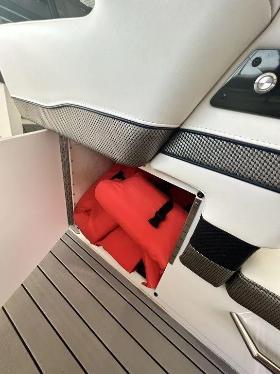 Slide: The Image of Storage compartment with red life jackets on a 2021 Formula 380 Super Sport Crossover boat. - 24