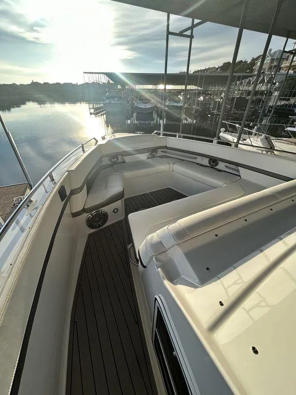 Slide: The Image of 2021 Formula 380 Super Sport Crossover boat docked at marina, sunlit deck view. - 29