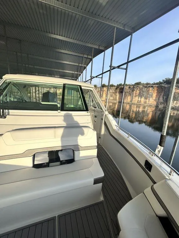 Slide: The Image of 2021 Formula 380 Super Sport Crossover boat docked under a covered marina. - 37