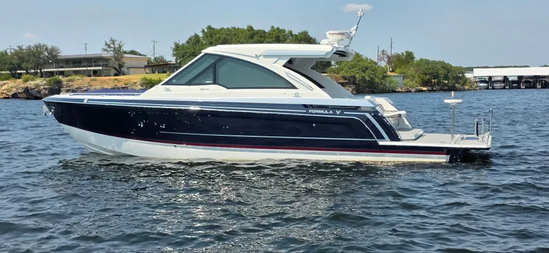 Slide: The Image of 2021 Formula 380 Super Sport Crossover boat on a calm lake. - 6